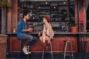 Young hip couple sitting at a restaurant's bar