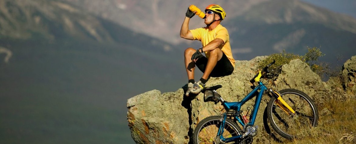 Bicyclist resting on mountain side enjoying view
