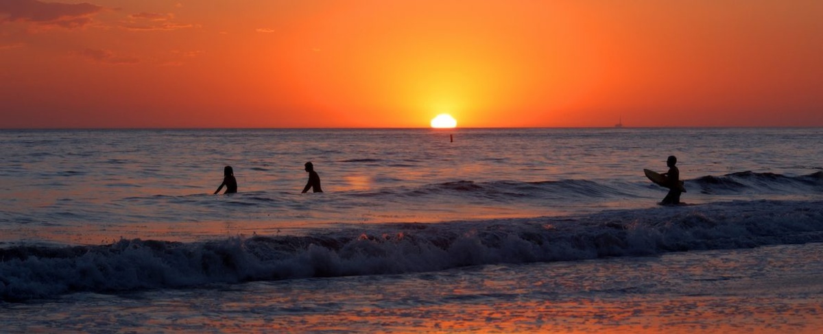 Surfing silhouettes at sunset at Arroyo Burro County Park