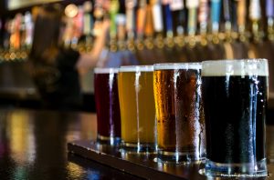 A flight of 4 craft beers lined up on the bar.